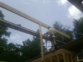 Carpenter setting a ridge beam over a new addition frame — Ice Dam Removal by Roofing Brothers in Pilot Point