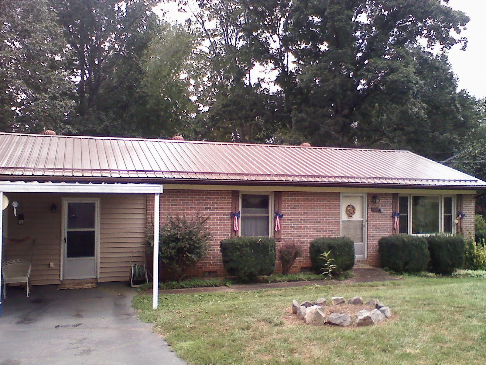 Bronze metal roof and carport on a brick ranch home — Roof Repair work by our crew in Pilot Point